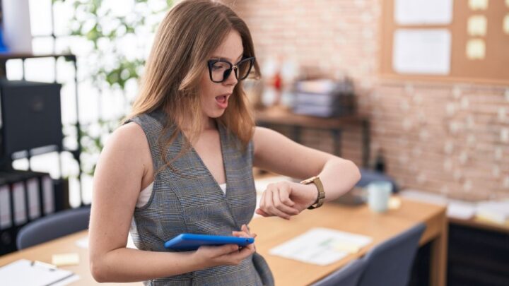 Trabajadora revisando su reloj mientras controla su control horario laboral